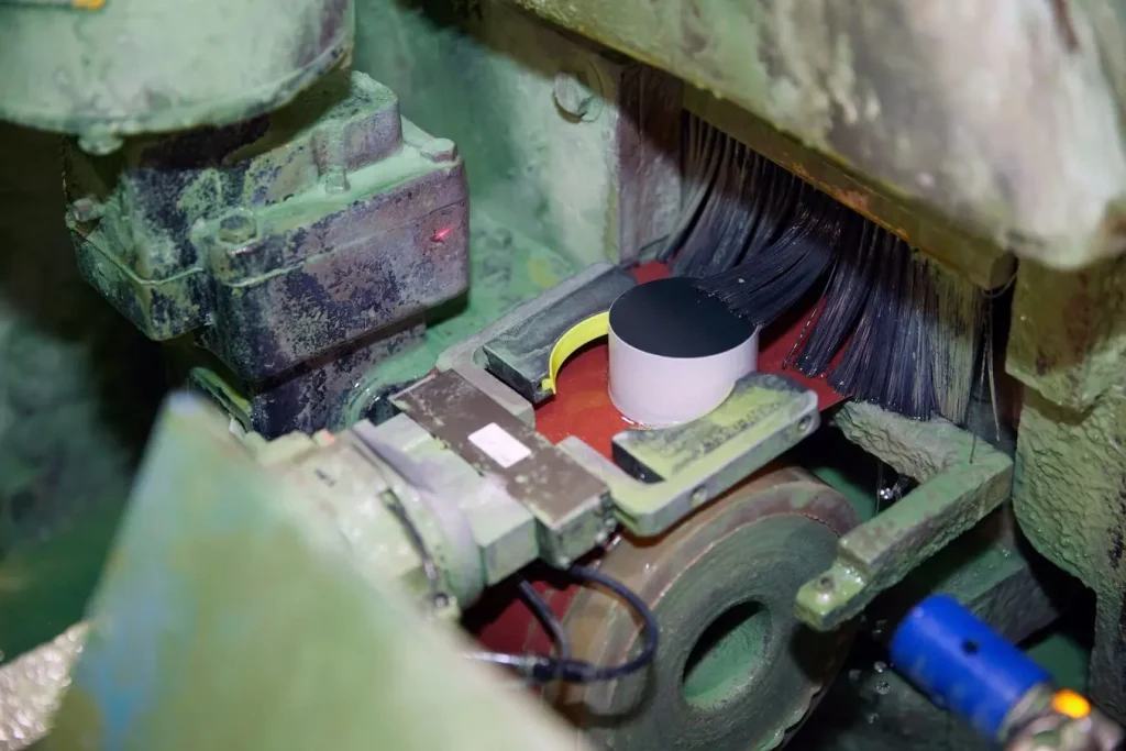 Cánh gạt (flipper arm) đảm nhiệm việc gắp các MOV cỡ lớn (station-class) và đưa chúng qua quá trình mài, nơi chúng liên tục tiếp xúc với dung dịch làm mát. Để tăng độ bám, bộ phận SLS được tích hợp thêm lớp TPU in FDM (màu vàng neon), được in thành dải dài rồi cắt theo kích thước phù hợp.